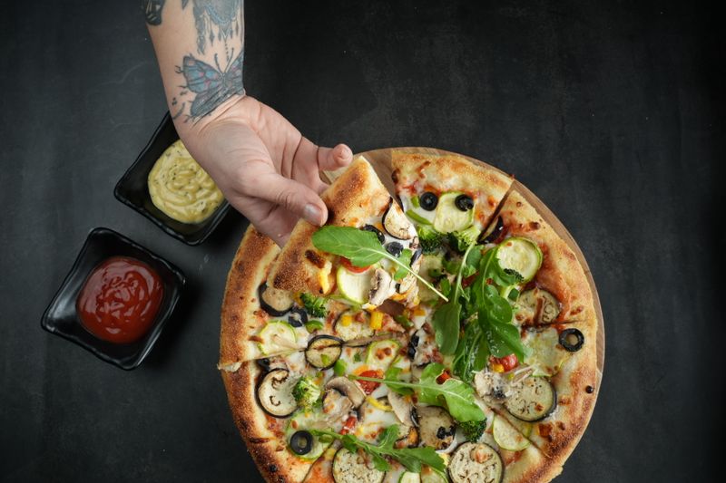 Vegane Pizza mit frischem Gemüse und Kräutern